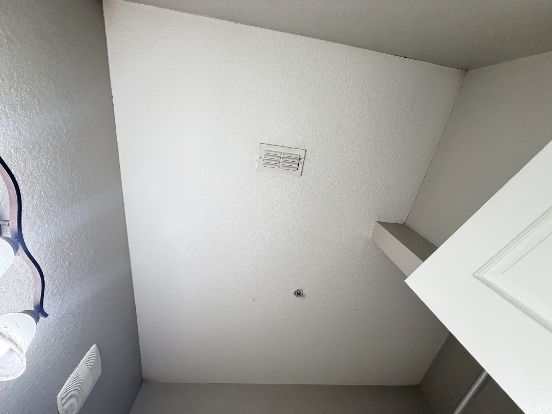 Clean textured white ceiling with a light fixture, after repainting